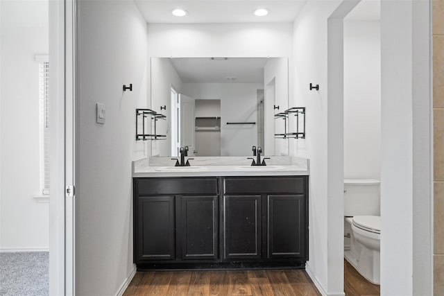 14428 Sugar Pines Dr, Conroe, TX 77302 - bathroom with double vanity, toilet, a sink, and wood finished floors