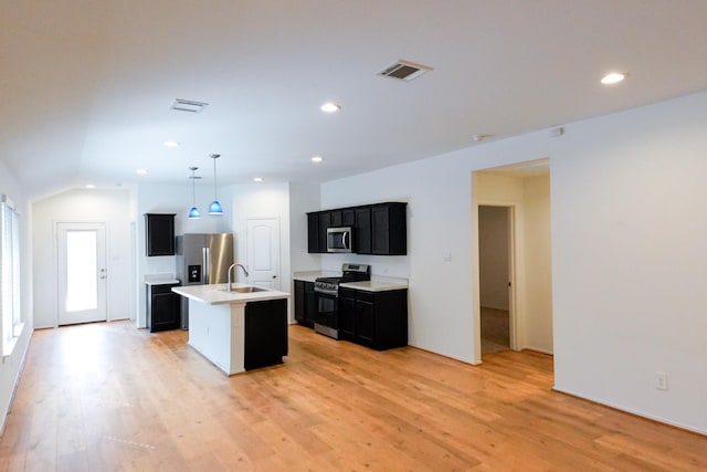 14428 Sugar Pines Dr, Conroe, TX 77302 - kitchen featuring visible vents, light countertops, a sink, dark cabinets, and stainless steel appliances