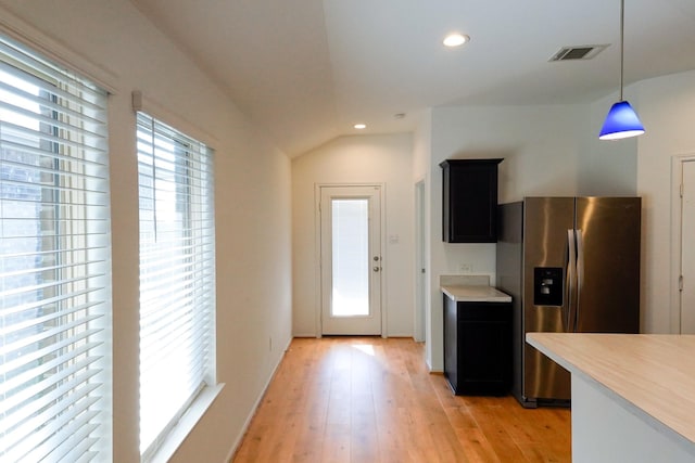 14428 Sugar Pines Dr, Conroe, TX 77302 - kitchen featuring stainless steel fridge with ice dispenser, light countertops, decorative light fixtures, light wood-type flooring, and visible vents