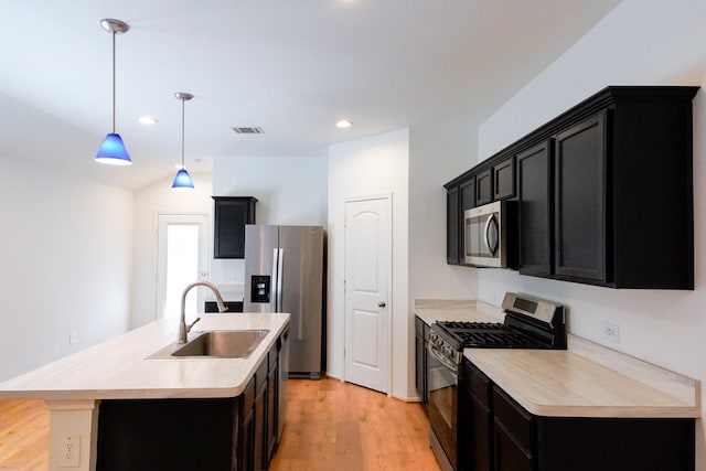 14428 Sugar Pines Dr, Conroe, TX 77302 - kitchen with visible vents, a sink, dark cabinetry, and appliances with stainless steel finishes