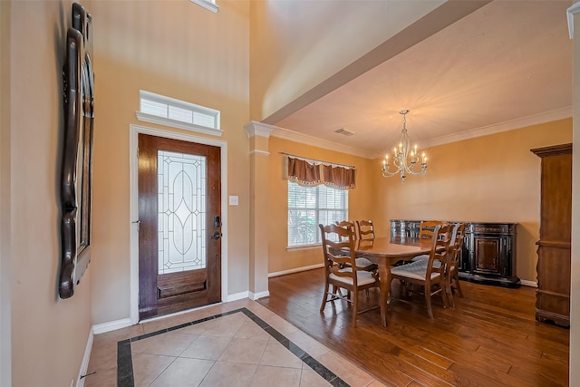 foyer entrance featuring ornamental molding, light wood-type flooring, baseboards, and an inviting chandelier