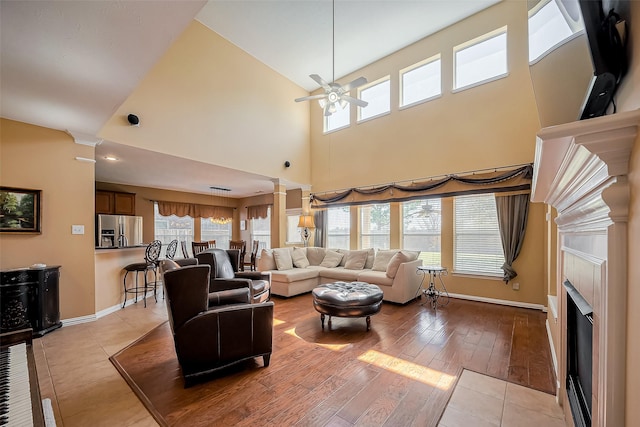 living room with a healthy amount of sunlight, a fireplace, decorative columns, and ceiling fan