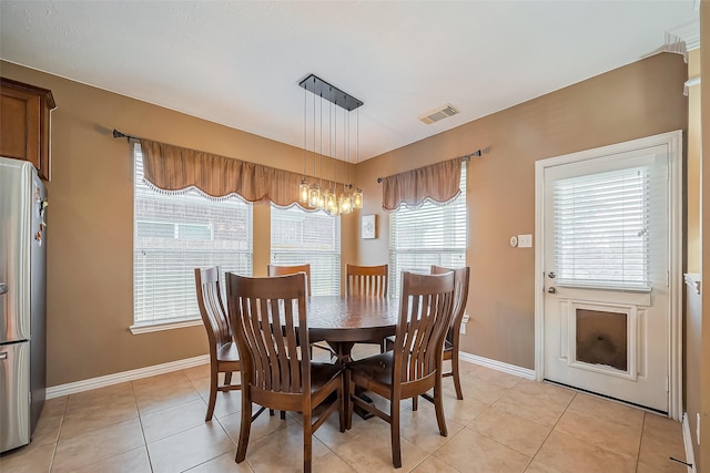 dining area with baseboards, visible vents, and light tile patterned flooring