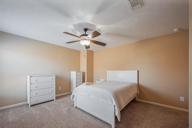 bedroom featuring baseboards, visible vents, ceiling fan, a textured ceiling, and carpet flooring