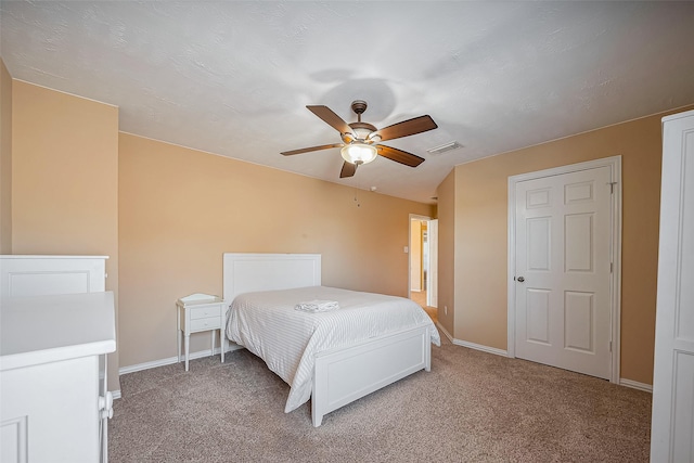 bedroom with baseboards, visible vents, and light colored carpet