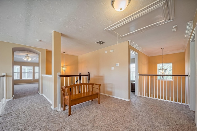 hall featuring plenty of natural light, attic access, visible vents, arched walkways, and carpet floors