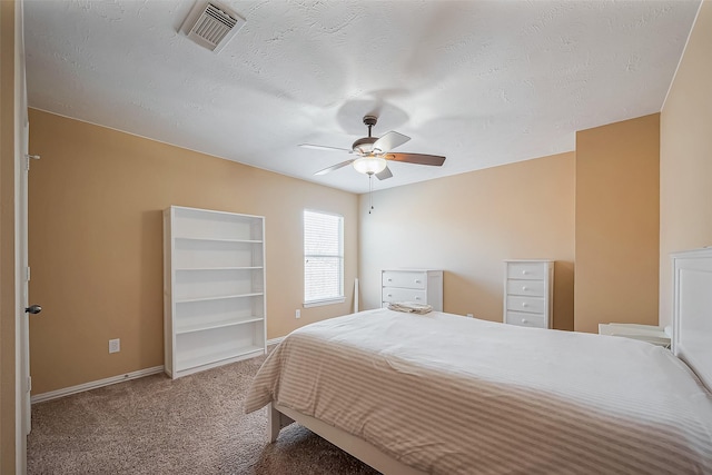 bedroom featuring a textured ceiling, carpet floors, visible vents, and baseboards