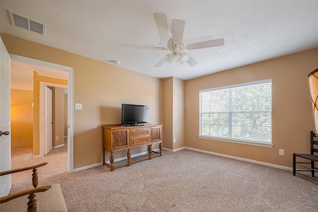 living room featuring baseboards, a textured ceiling, visible vents, and carpet flooring