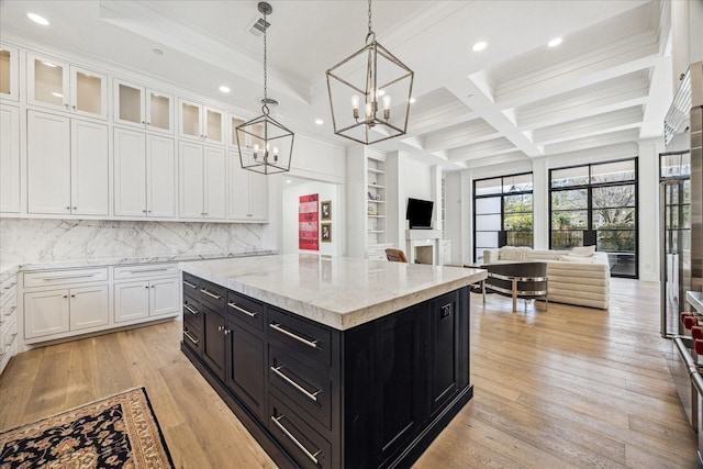 kitchen featuring open floor plan, dark cabinetry, a center island, and white cabinets