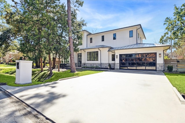 modern farmhouse style home with stone siding, a front yard, and a standing seam roof