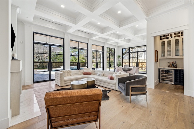 living room featuring a dry bar, beverage cooler, coffered ceiling, light wood-style flooring, and beam ceiling