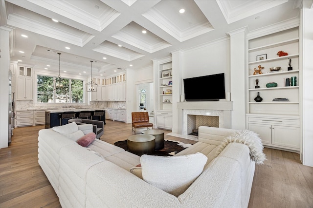 living area with ornamental molding, beamed ceiling, coffered ceiling, and wood finished floors