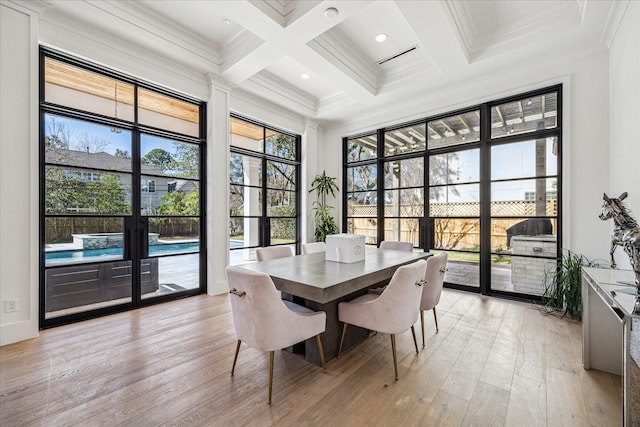 dining room featuring ornamental molding, light wood-type flooring, coffered ceiling, and beam ceiling