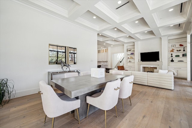 dining area with a fireplace, stairway, light wood-style flooring, coffered ceiling, and beamed ceiling