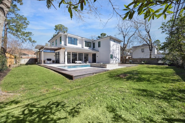 rear view of property featuring stucco siding, a fenced backyard, a yard, and a pergola