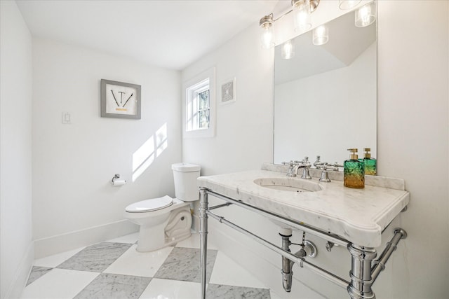 half bath featuring baseboards, visible vents, a sink, and toilet