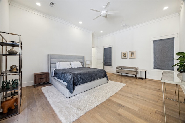 bedroom featuring baseboards, light wood-style flooring, visible vents, and crown molding