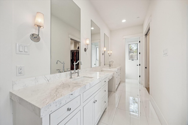 full bathroom with a spacious closet, two vanities, a sink, and tile patterned floors