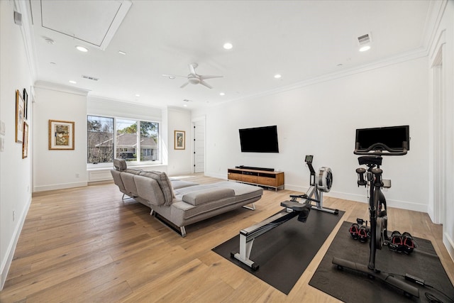 exercise area with ornamental molding, light wood-type flooring, and visible vents