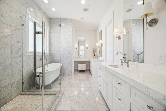 full bath with a freestanding tub, visible vents, two vanities, and a sink