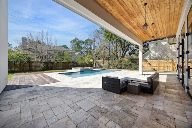 view of swimming pool with a pool with connected hot tub, a fenced backyard, and a patio