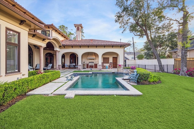 exterior space featuring fence, stucco siding, a tiled roof, a patio area, and a lawn