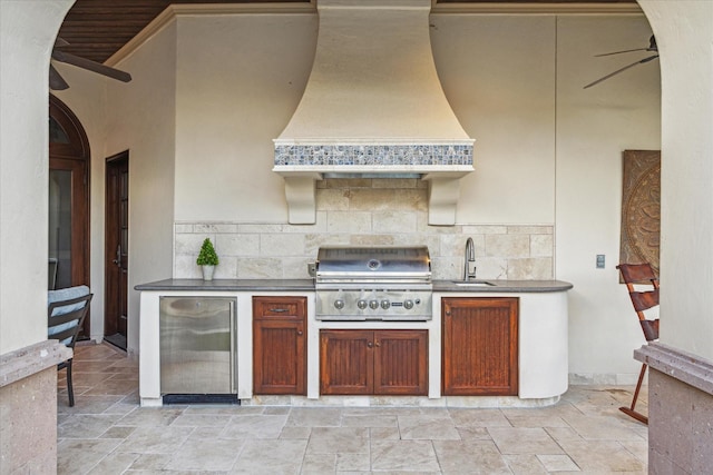 kitchen featuring custom range hood, a sink, backsplash, stainless steel fridge, and arched walkways