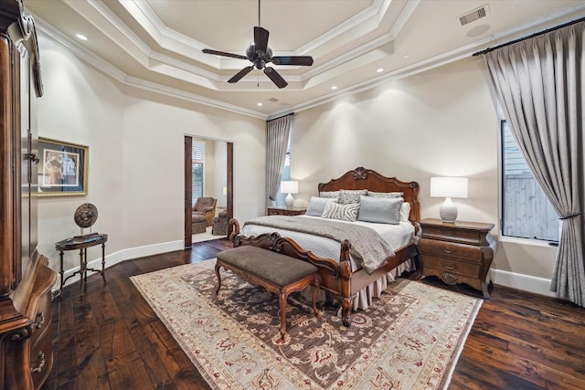 bedroom with baseboards, visible vents, dark wood-type flooring, crown molding, and a raised ceiling