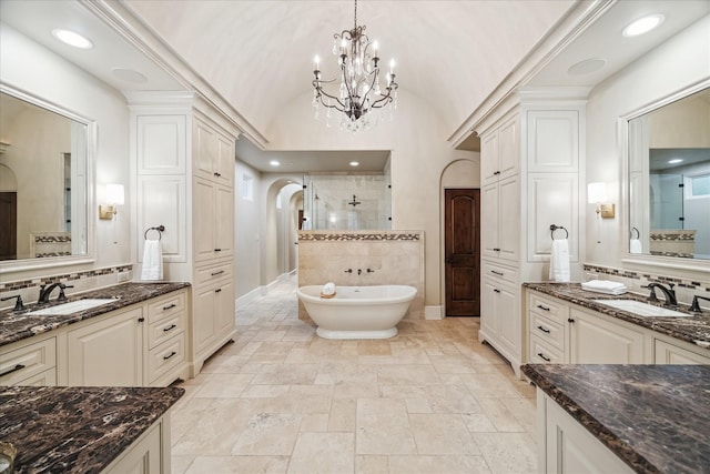 full bath featuring a sink, baseboards, a tile shower, and vaulted ceiling