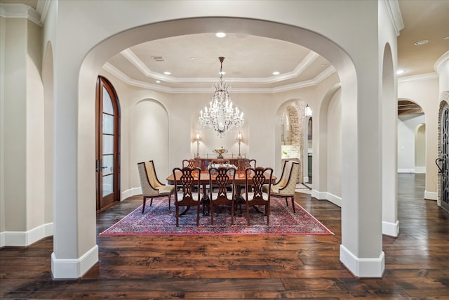 dining area with a tray ceiling, visible vents, wood-type flooring, and an inviting chandelier