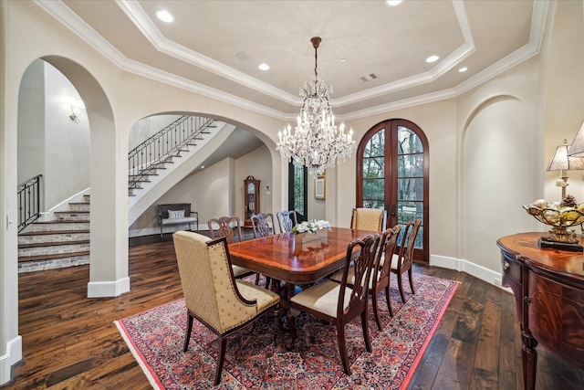 dining area featuring stairs, a tray ceiling, and dark wood-style flooring