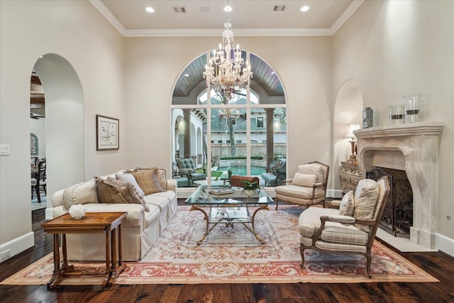 living area featuring a premium fireplace, arched walkways, wood-type flooring, and a chandelier