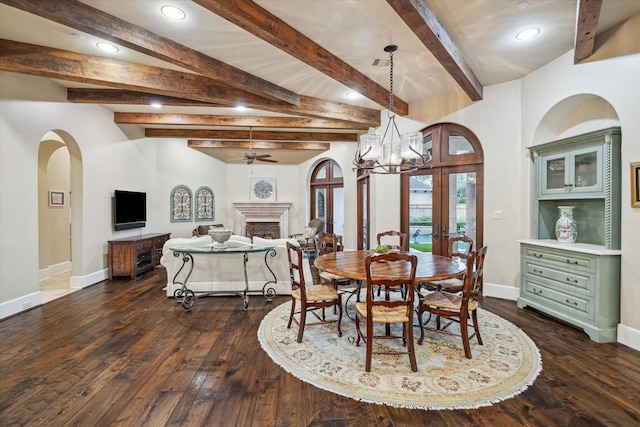 dining space featuring dark wood finished floors, french doors, arched walkways, a fireplace, and baseboards