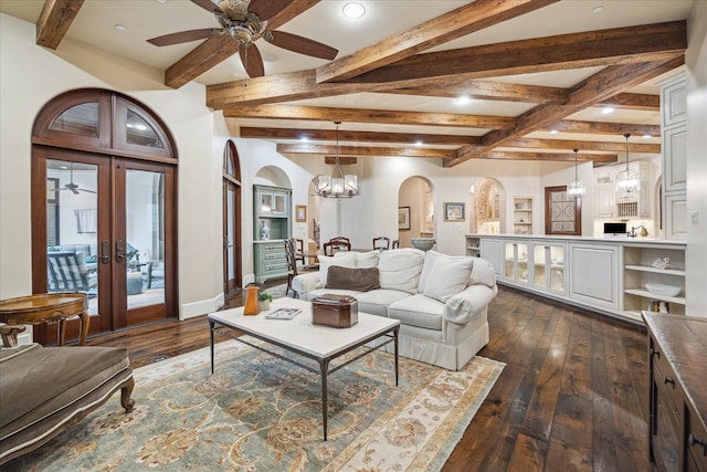 living area featuring dark wood-type flooring, baseboards, ceiling fan with notable chandelier, french doors, and arched walkways