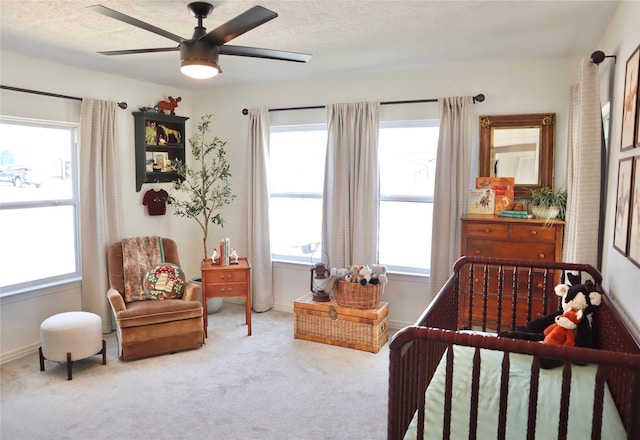 bedroom featuring multiple windows, a textured ceiling, carpet, and a ceiling fan