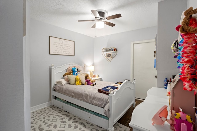 bedroom featuring baseboards, a ceiling fan, and a textured ceiling