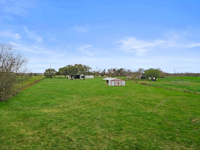 view of yard featuring a rural view and an outdoor structure