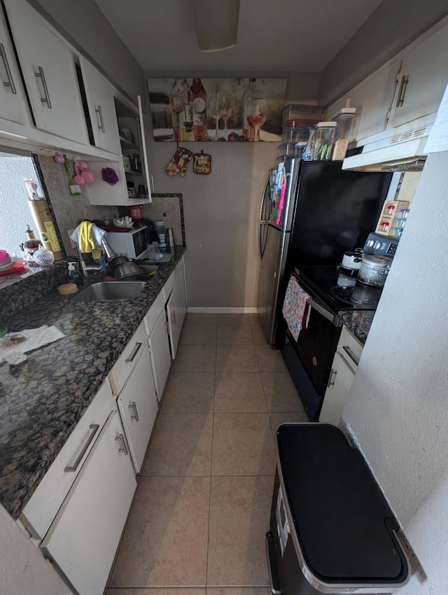 kitchen featuring under cabinet range hood, white cabinets, a sink, and light tile patterned flooring