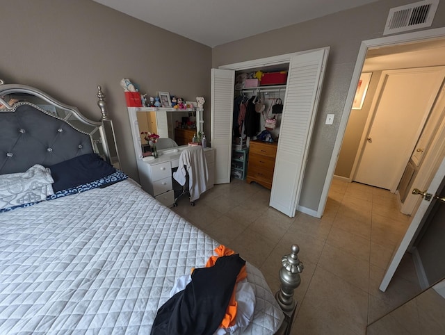 bedroom featuring a closet, light tile patterned flooring, and visible vents