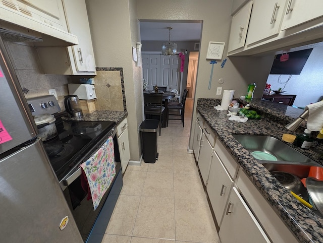 kitchen featuring light tile patterned flooring, under cabinet range hood, white cabinets, decorative backsplash, and electric range oven