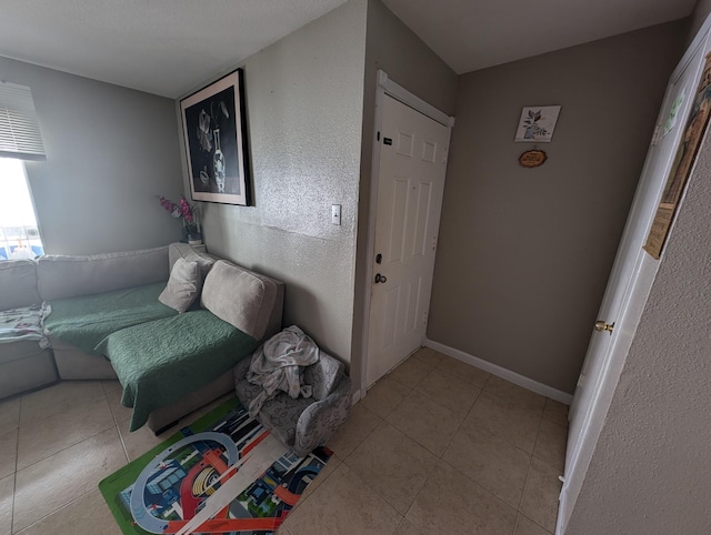 interior space with baseboards and light tile patterned floors