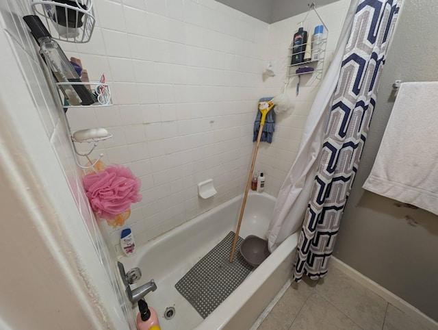 bathroom with tile patterned flooring, shower / bathtub combination with curtain, and baseboards