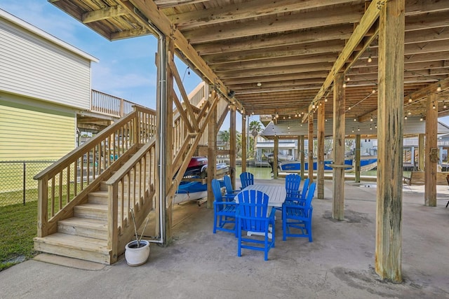 view of patio / terrace featuring fence and stairway