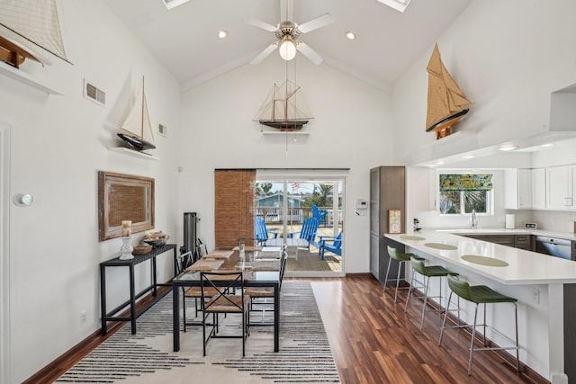 dining space with high vaulted ceiling, baseboards, visible vents, and dark wood-type flooring