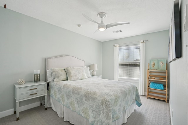 bedroom featuring light colored carpet, visible vents, ceiling fan, and baseboards