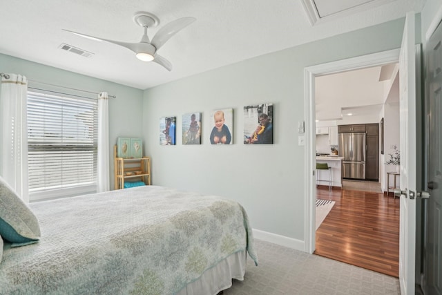 bedroom with ceiling fan, baseboards, visible vents, and stainless steel refrigerator