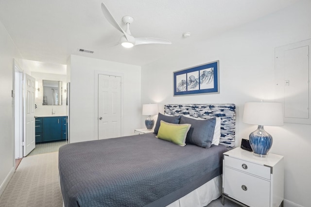 bedroom with ensuite bath, visible vents, ceiling fan, and baseboards