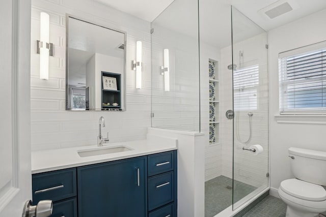 bathroom featuring a stall shower, visible vents, toilet, vanity, and backsplash