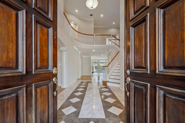 foyer entrance with recessed lighting, crown molding, decorative columns, baseboards, and stairs