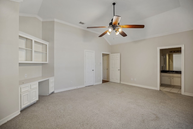 unfurnished bedroom with visible vents, crown molding, baseboards, light colored carpet, and built in desk